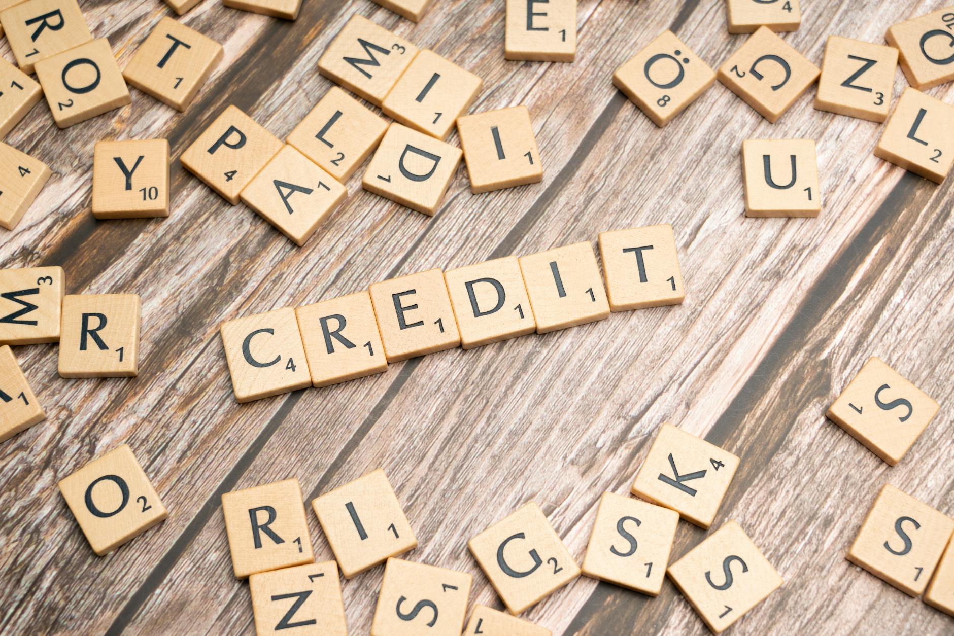 Drewniane kostki z napisem CREDIT leżące na starym drewnianym stole