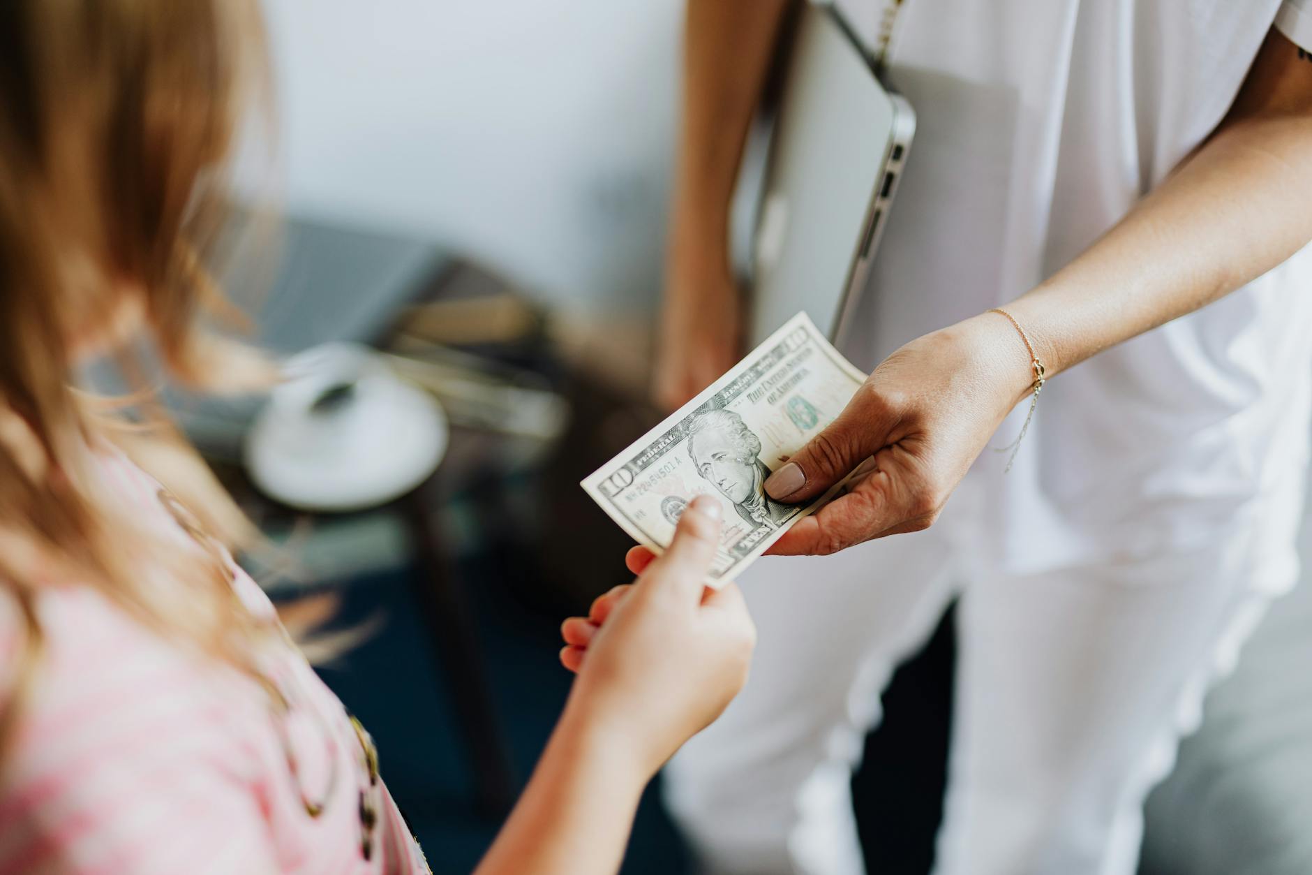 Zbliżenie na przekazywanie banknotu dolara między dwiema osobami