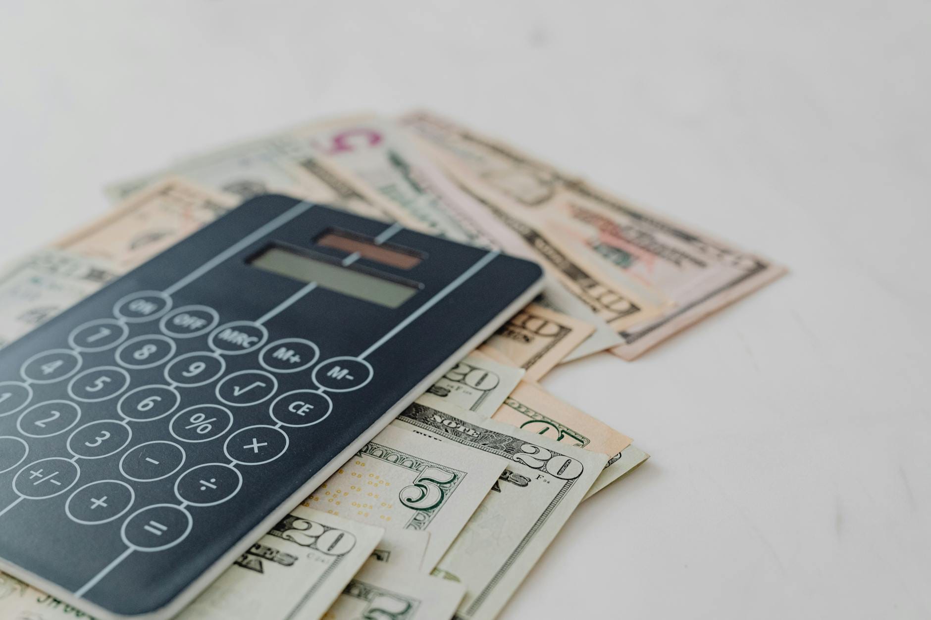Kalkulator i banknoty dolarowe używane do obliczania kosztów kredytu