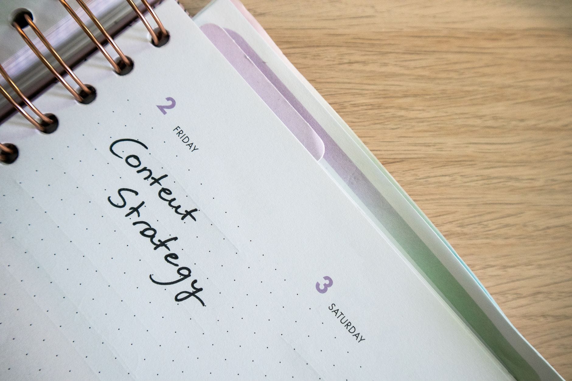 Planner z napisem Content Strategy na biurku jako plan treści na bloga
