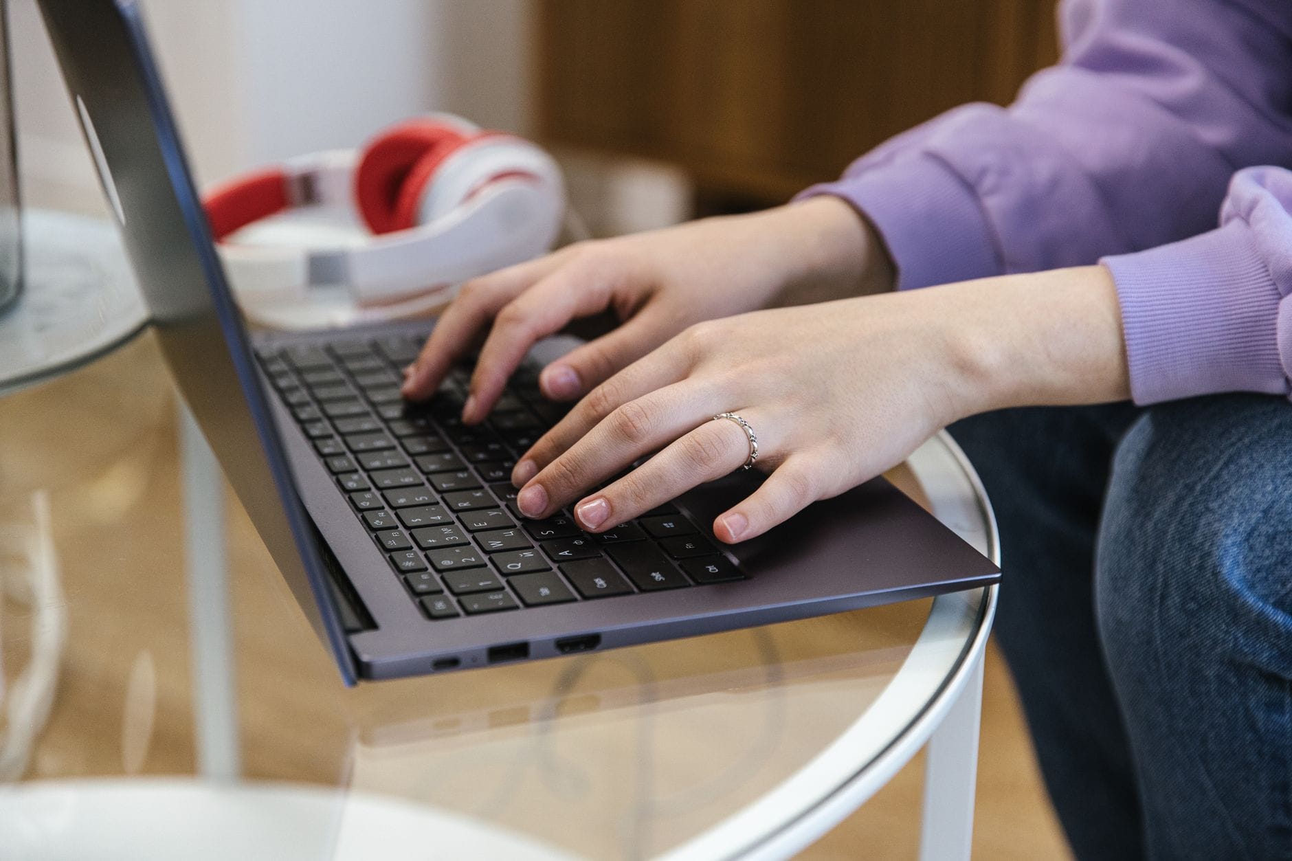 Dłonie czytelnika piszącego artykuł na laptopie w domu