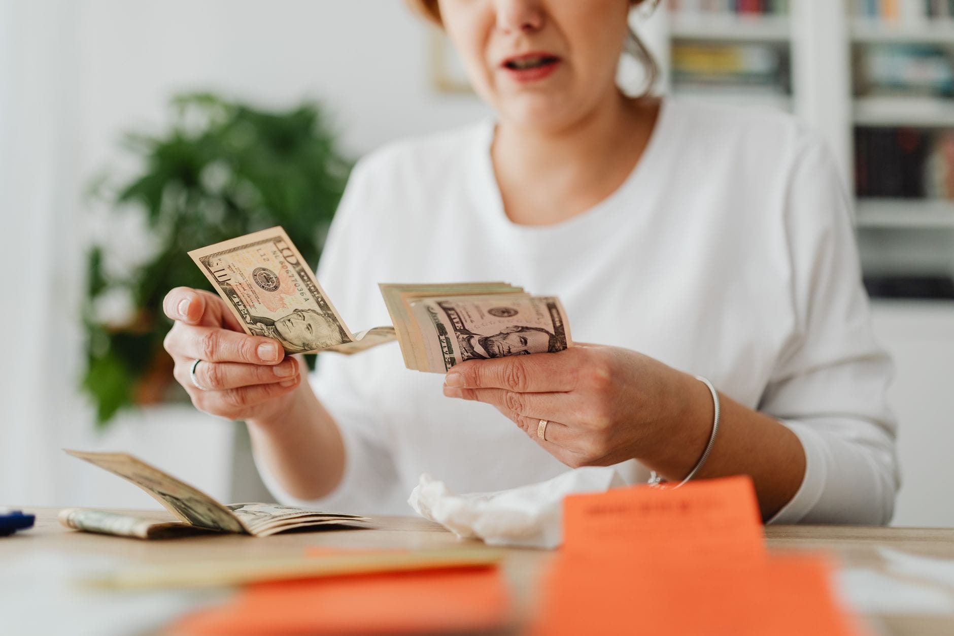 Kobieta w biurze liczy gotówkę, analizując swoją zdolność kredytową