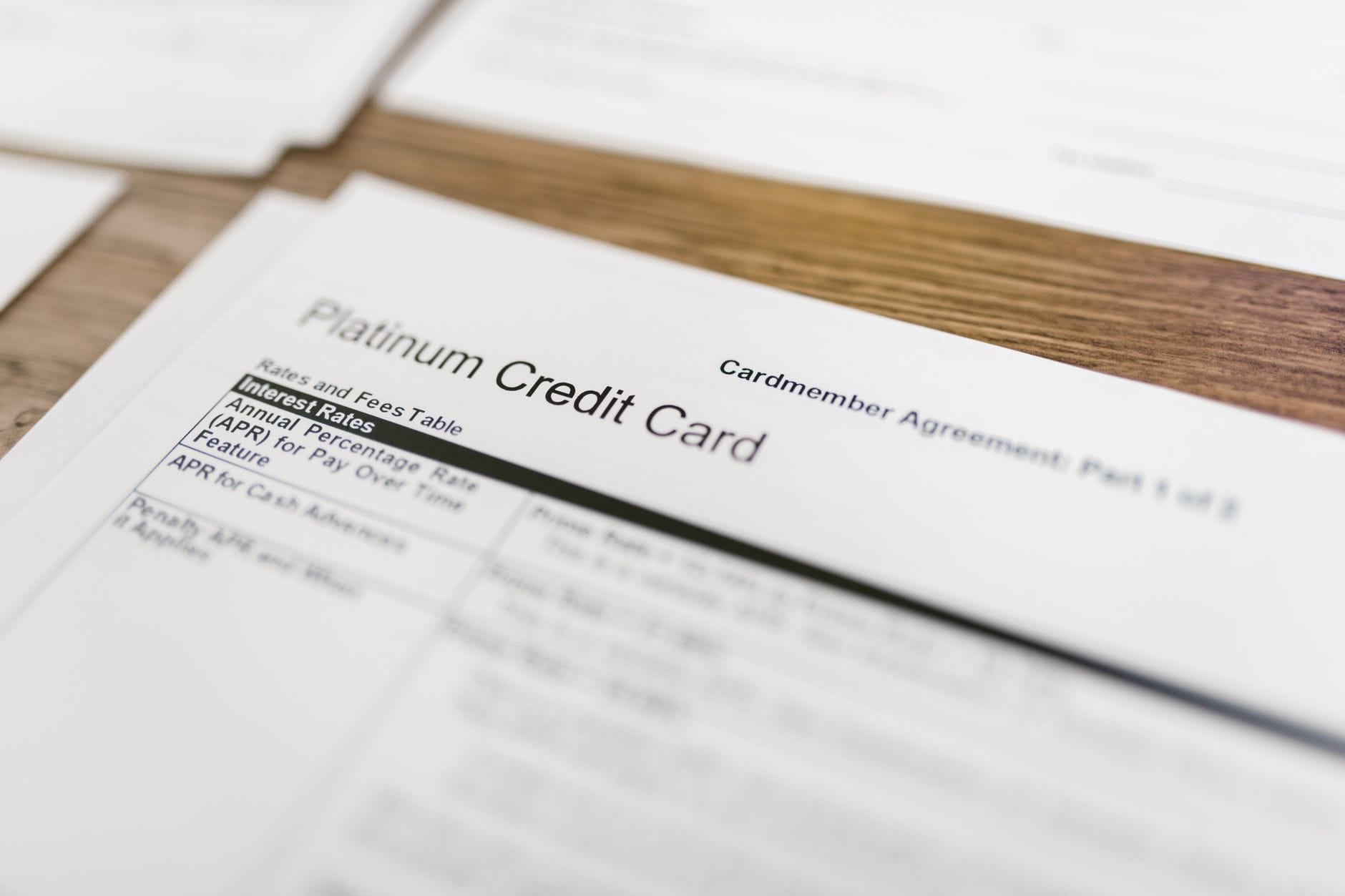 Zbliżenie na umowę karty kredytowej platinum leżącą na drewnianym biurku