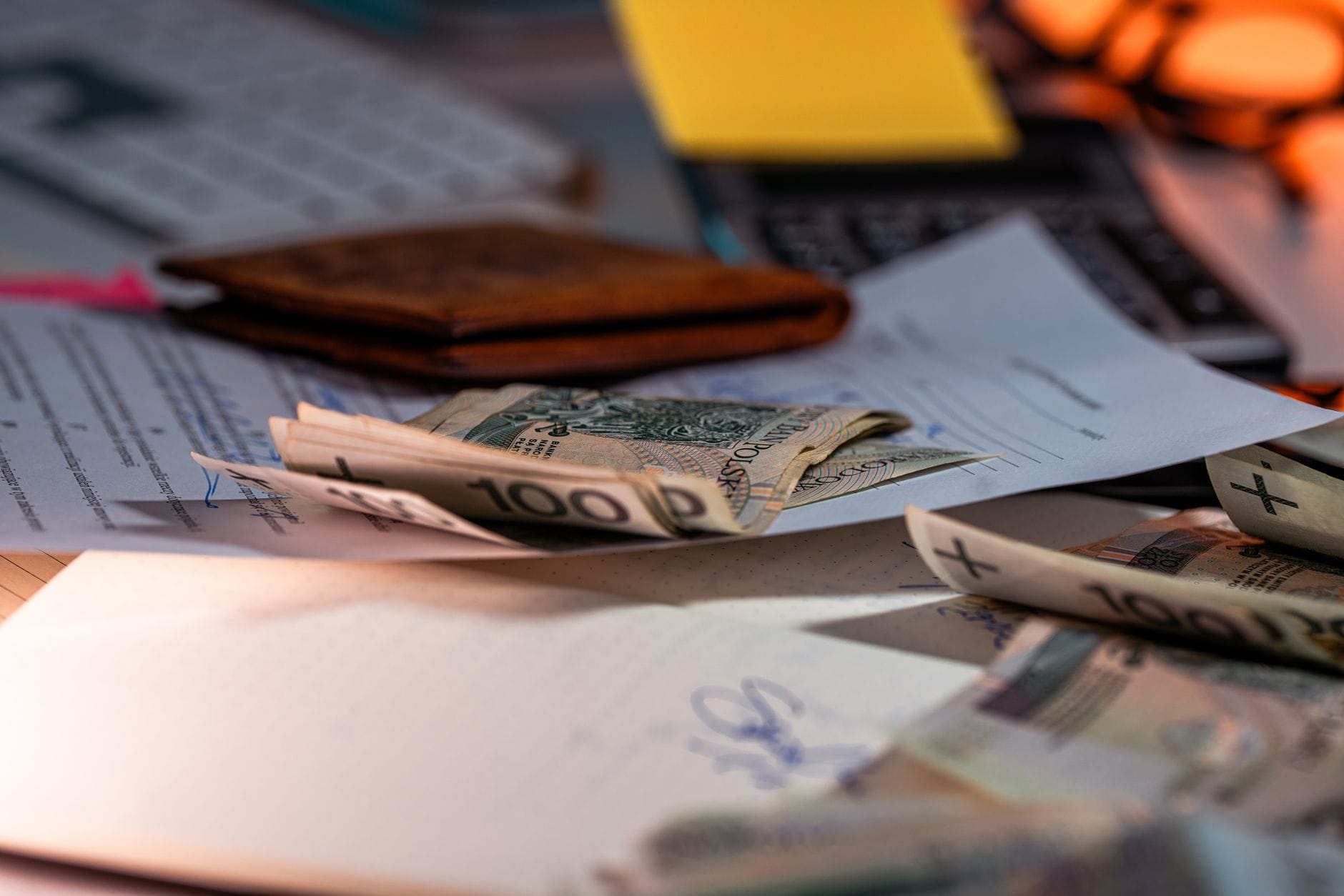 Banknoty złotowe i dokumenty finansowe rozłożone na biurku