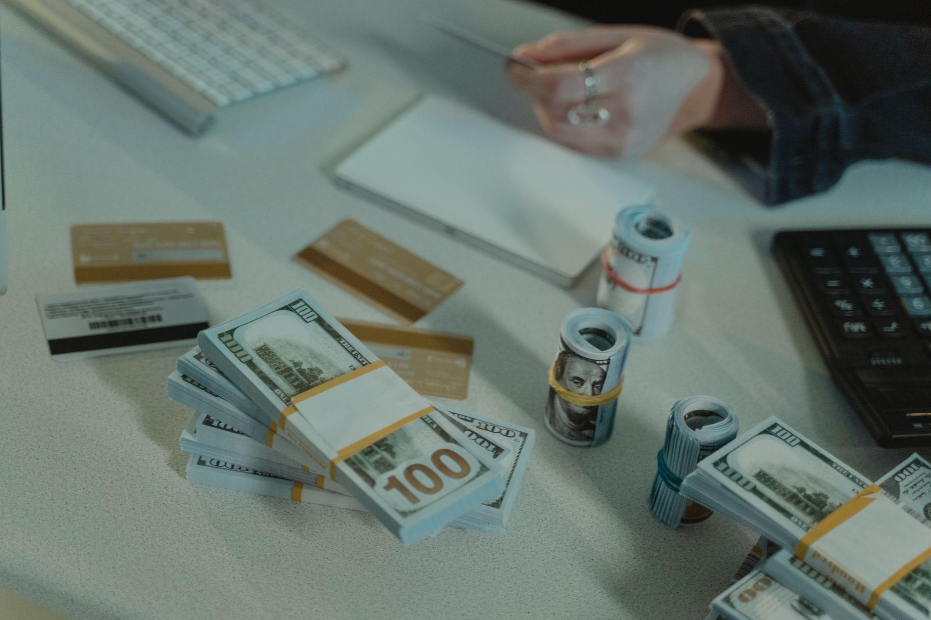 Banknoty dolarowe i karty kredytowe leżące na biurku