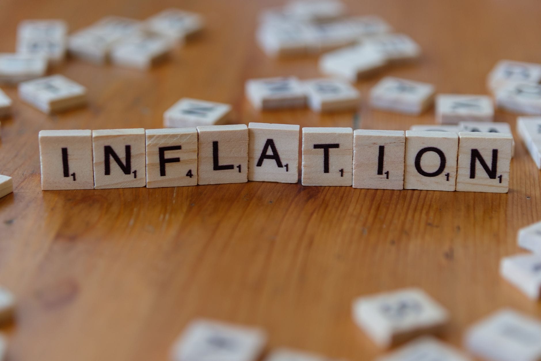 Kafle Scrabble tworzące napis INFLATION na drewnianym stole