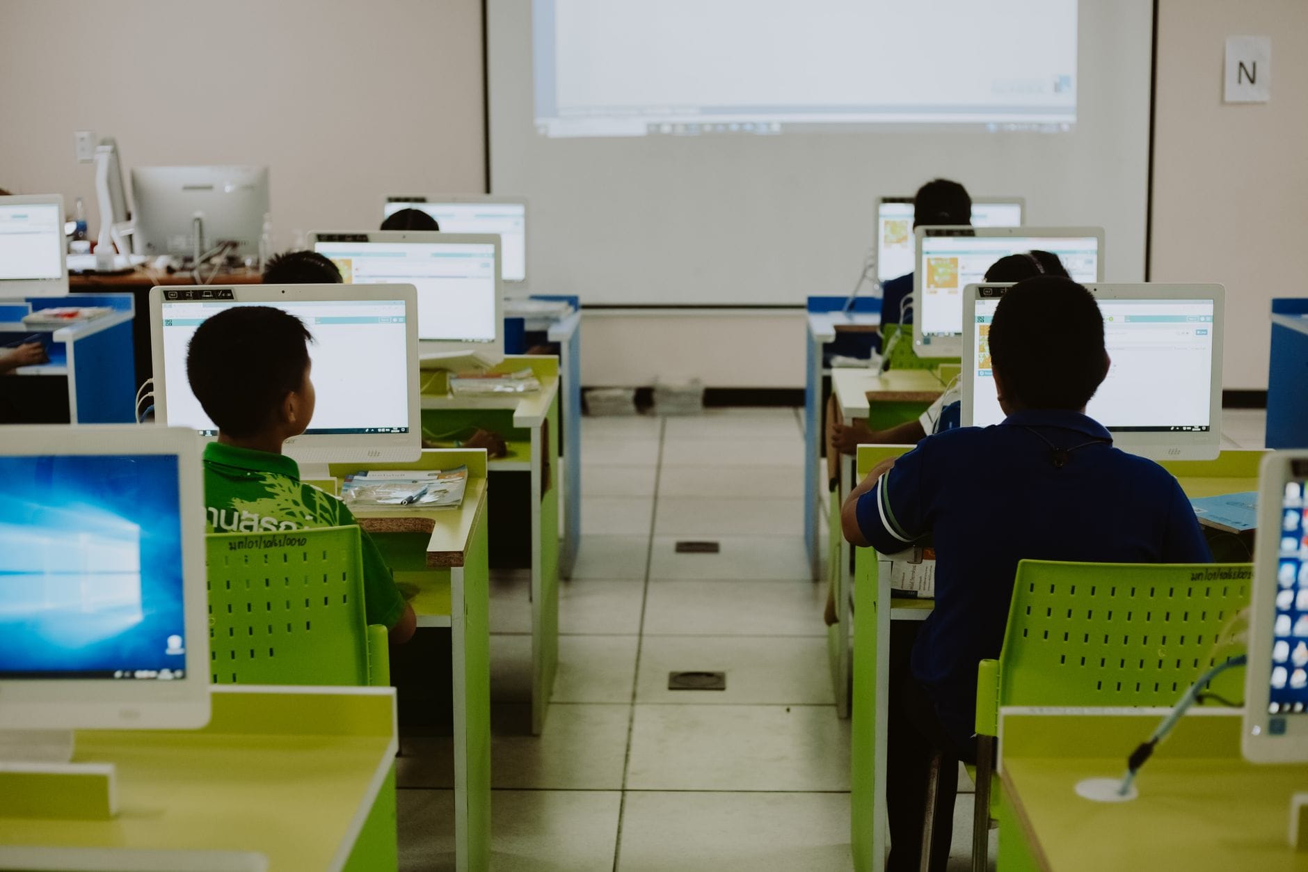 Uczniowie pracują przy komputerach w nowoczesnej szkolnej pracowni